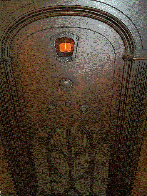 Philco 90L cabinet after repair, with the tuning frequency display light on and new grille fabric in place